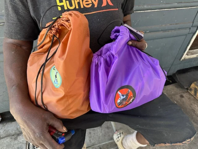Big Marv's Legacy outreach bags being carried during a community outreach day